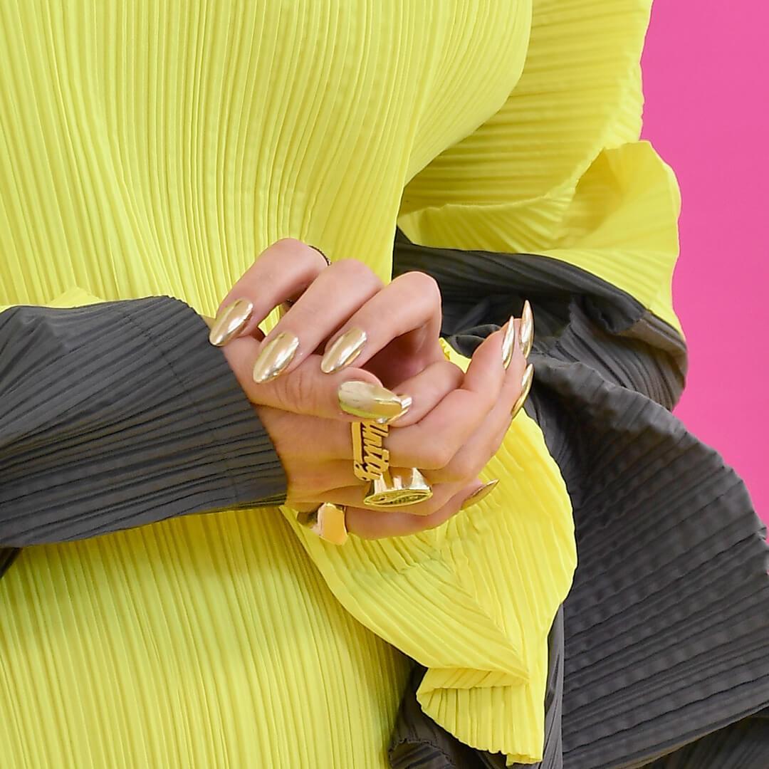 Close-up of Katy Perry's chrome nails against her slime green and dark gray dress Desktop