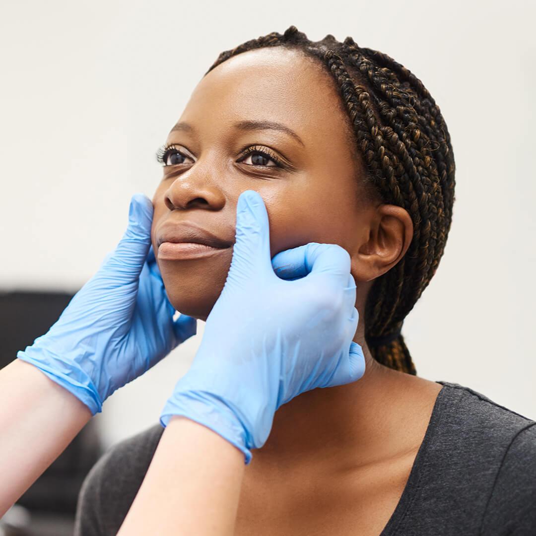 A photo of a woman getting her face analyzed by a nurse at a beauty clinic Desktop