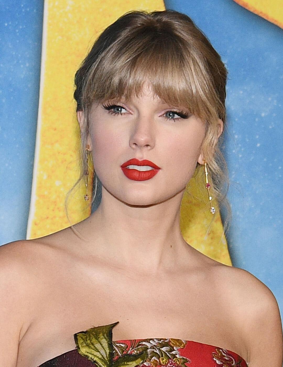 Taylor Swift rocking the red carpet in a floral dress and neutral makeup with red lips Desktop