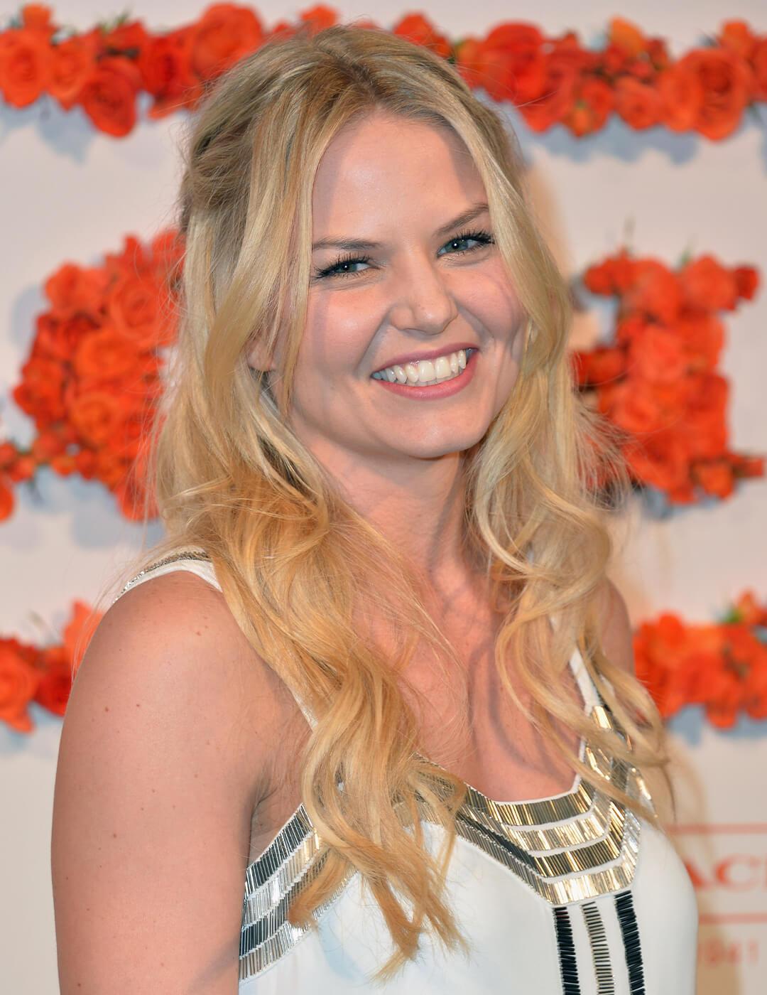 Jennifer Morrison smiling and rocking a half-up waterfall braids hairstyle against a wall of roses Desktop
