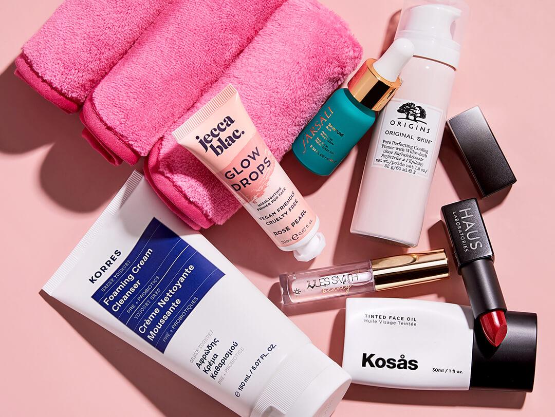 Flat lay image of makeup and skincare products and tools on light pink background Desktop