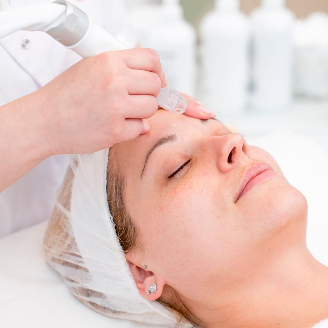 Image of a woman getting a microdermabrasion facial treatment Desktop