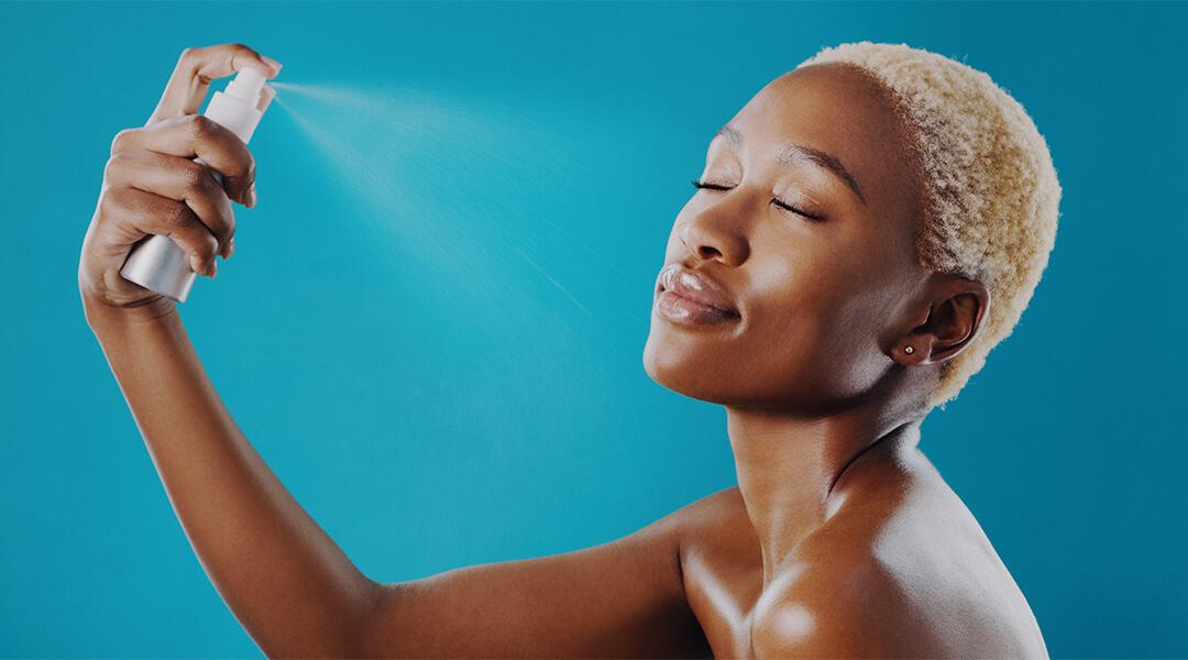 Cropped shot of a beautiful young woman applying setting spray to her face Desktop