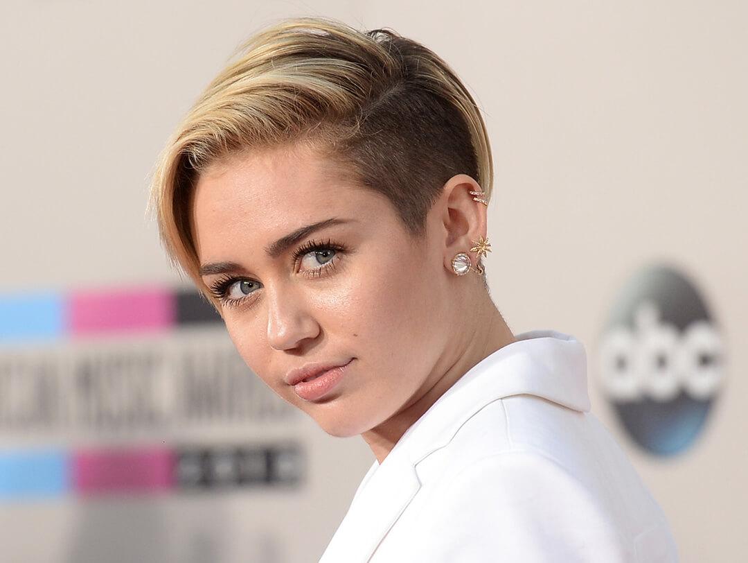 Close-up of Miley Cyrus rocking a long pixie undercut hairstyle and white suit on the red carpet Desktop