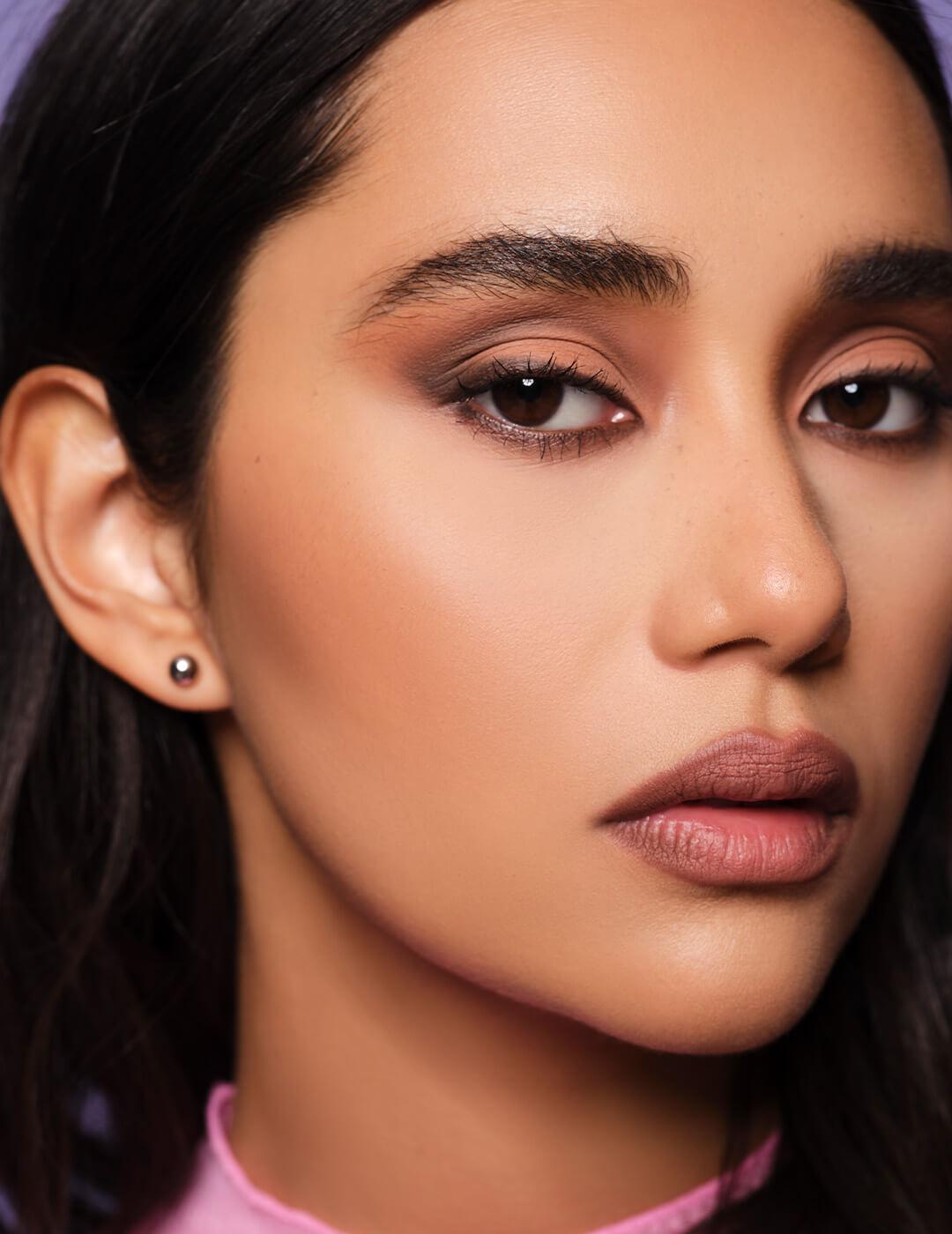 Close-up quarter profile of a model rocking Ash K Holm's signature sultry eye makeup look Mobile