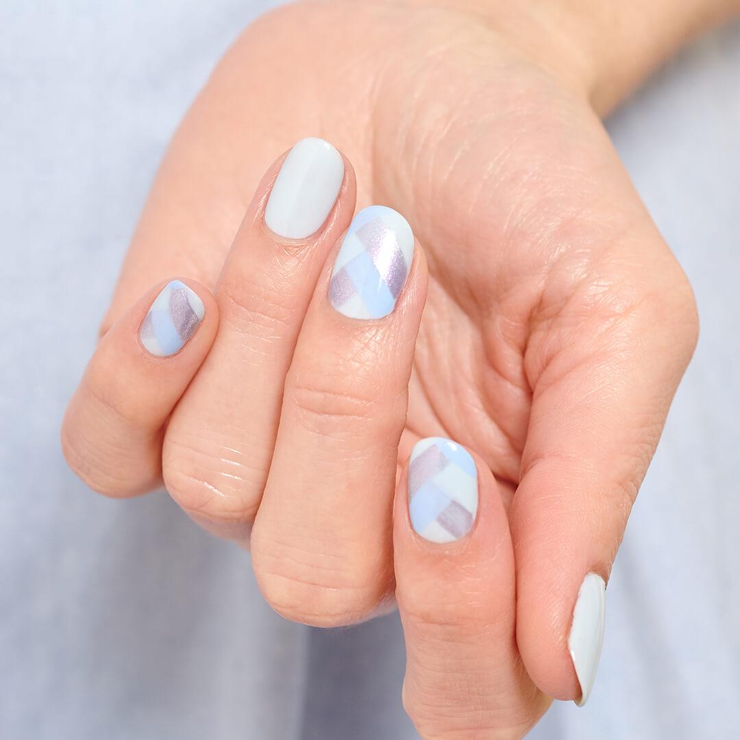 Close-up image of a hand with light blue scales nail art mani Desktop