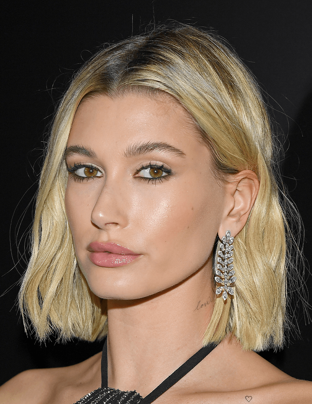 Hailey Bieber rocking a bob hairstyle, neutral makeup look, and dangling diamond earrings Desktop