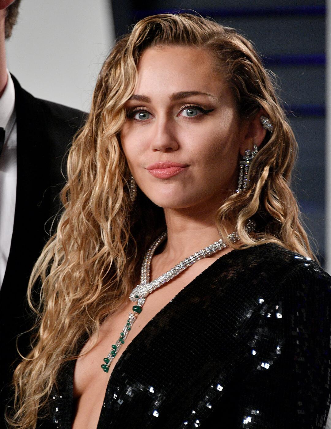 Miley Cyrus looking glam in a wet look curly hairstyle and black sequined dress Mobile