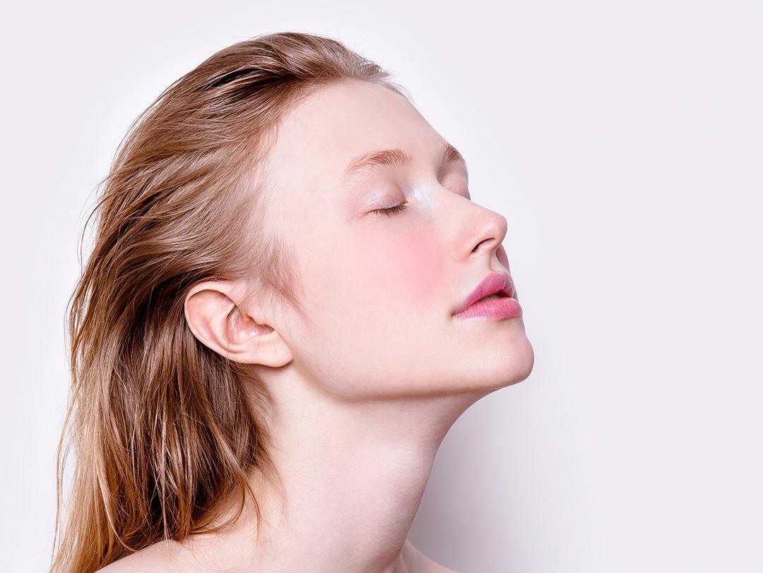 A photo of a model with her eyes closed looking fresh with rosy cheeks Desktop