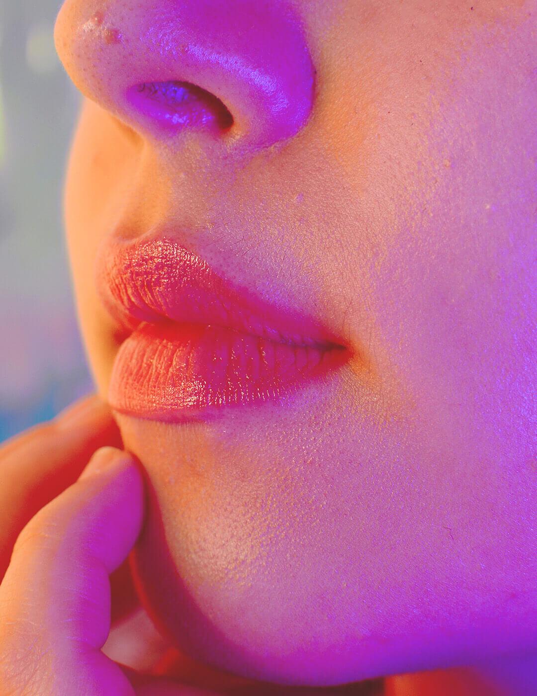 A close-up image of a woman's rosy lips while she undergoes a snow mushroom skincare routine, enhancing the radiance of her clear skin Desktop