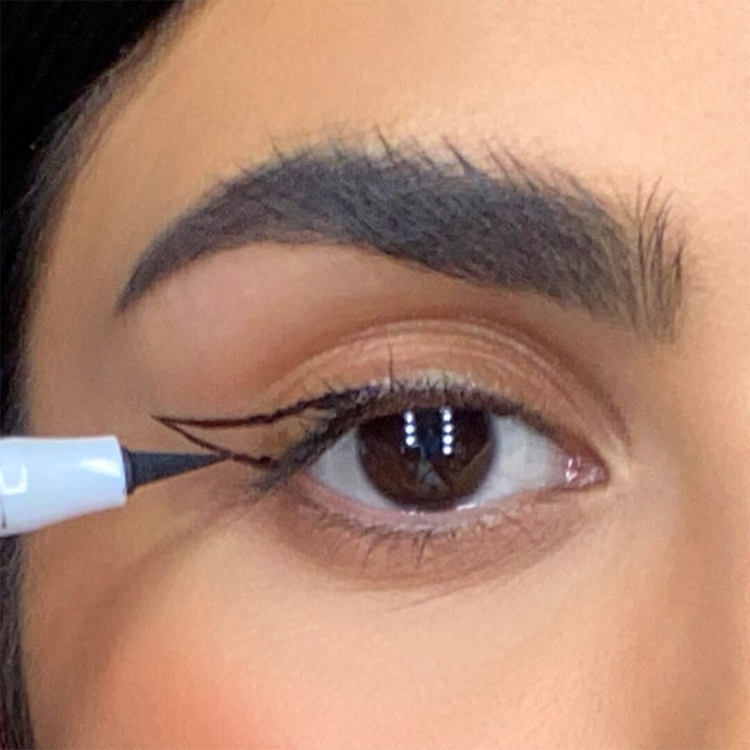 Close-up of a woman connecting her cat eye guide with an eyeliner Desktop