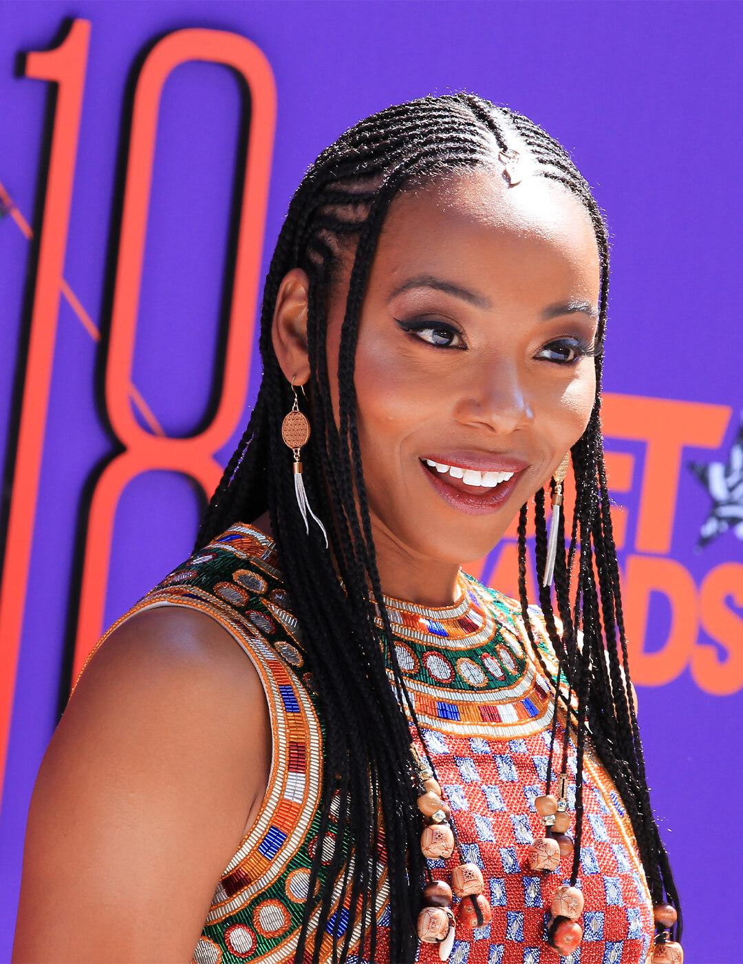 Erica Ash wearing a tribal-patterned dress and rocking Fulani Braids hairstyle Mobile