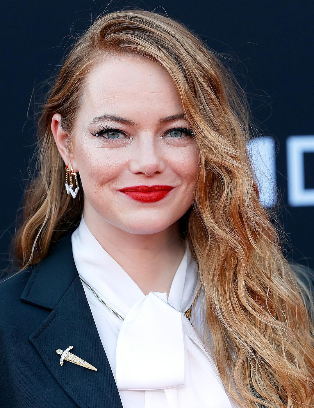 A photo of Emma Stone with strawberry golden hair with pearl beads on her eyelids and wearing a bold red lipstick Mobile