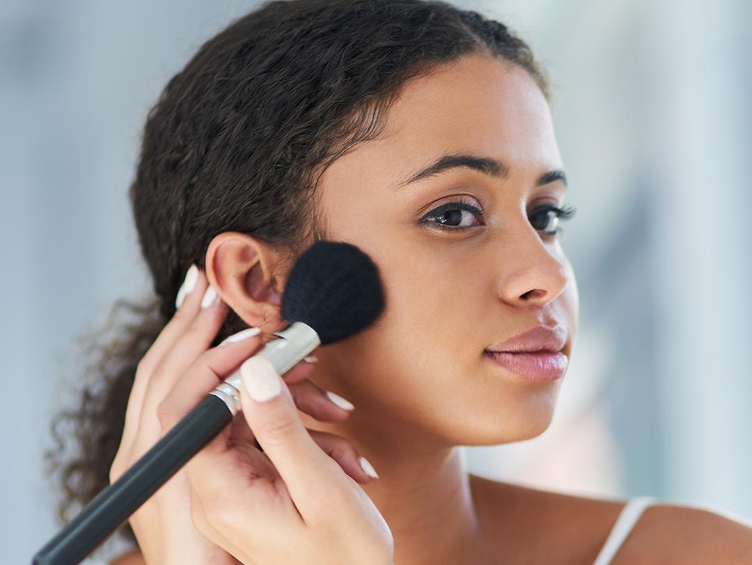 A photo of a woman applying blush Desktop