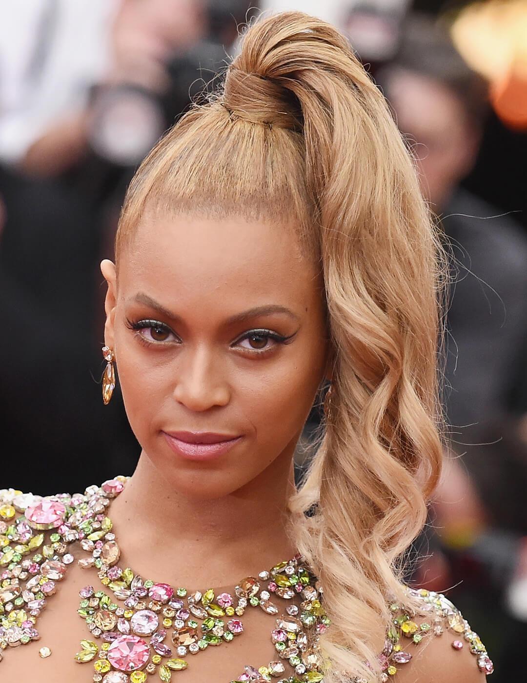 A close-up image of Beyonce wearing a dress accentuated with colorful beads with her hair on one side Mobile