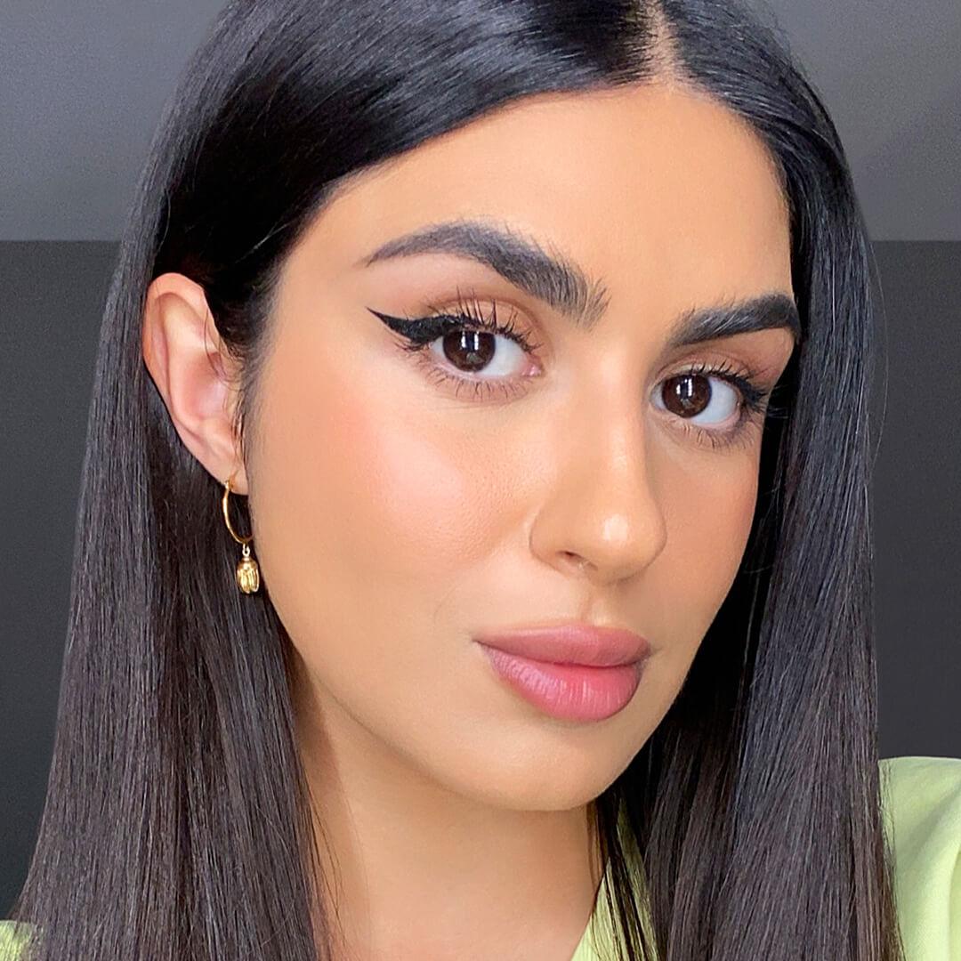 Close-up of a model rocking a bold winged eyeliner look paired with pink lips Mobile