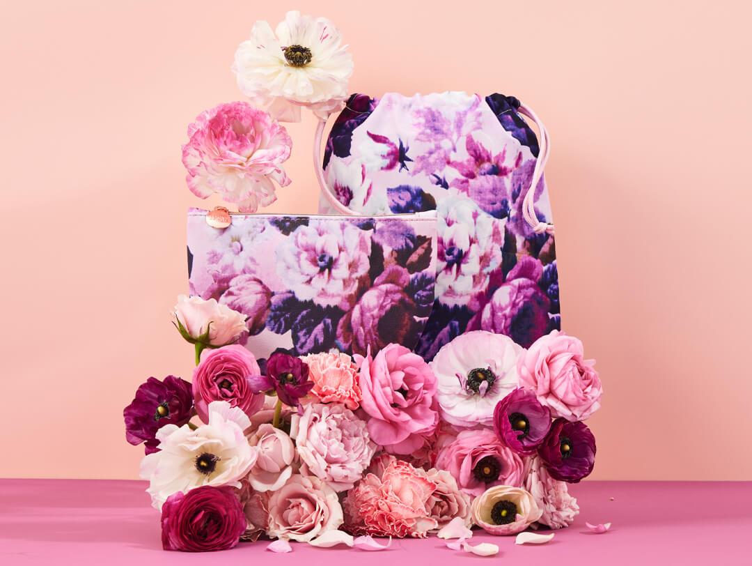May 2022 Glam Bag and Glam Bag Plus bags and colorful flowers on pink background Desktop