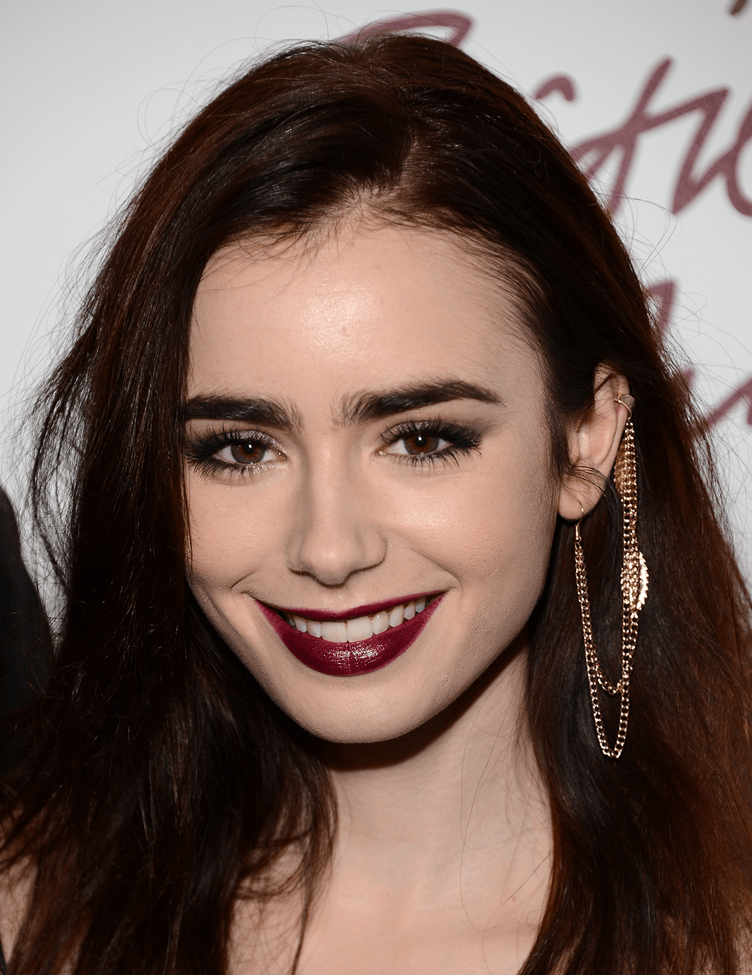 Close-up of a smiling Lily Collins rocking a glossy, dark berry lipstick look Desktop
