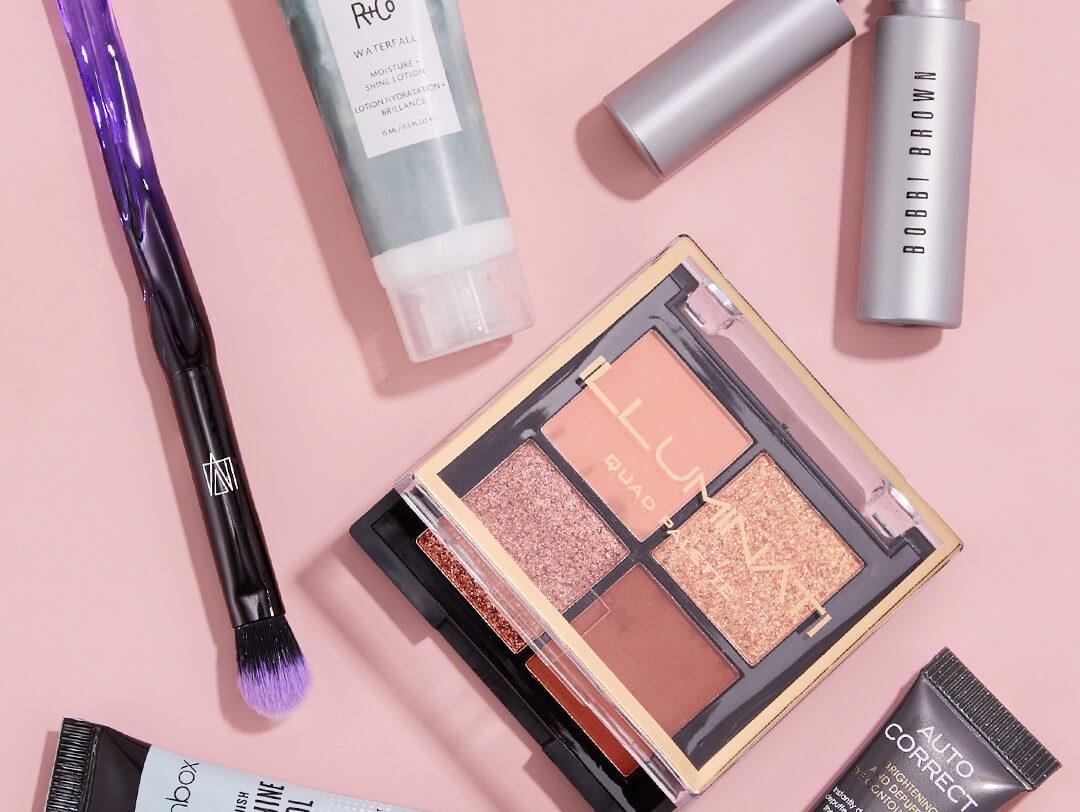 Skincare and makeup products and makeup brush from IPSY November 2020 Glam Bag on pink background Desktop