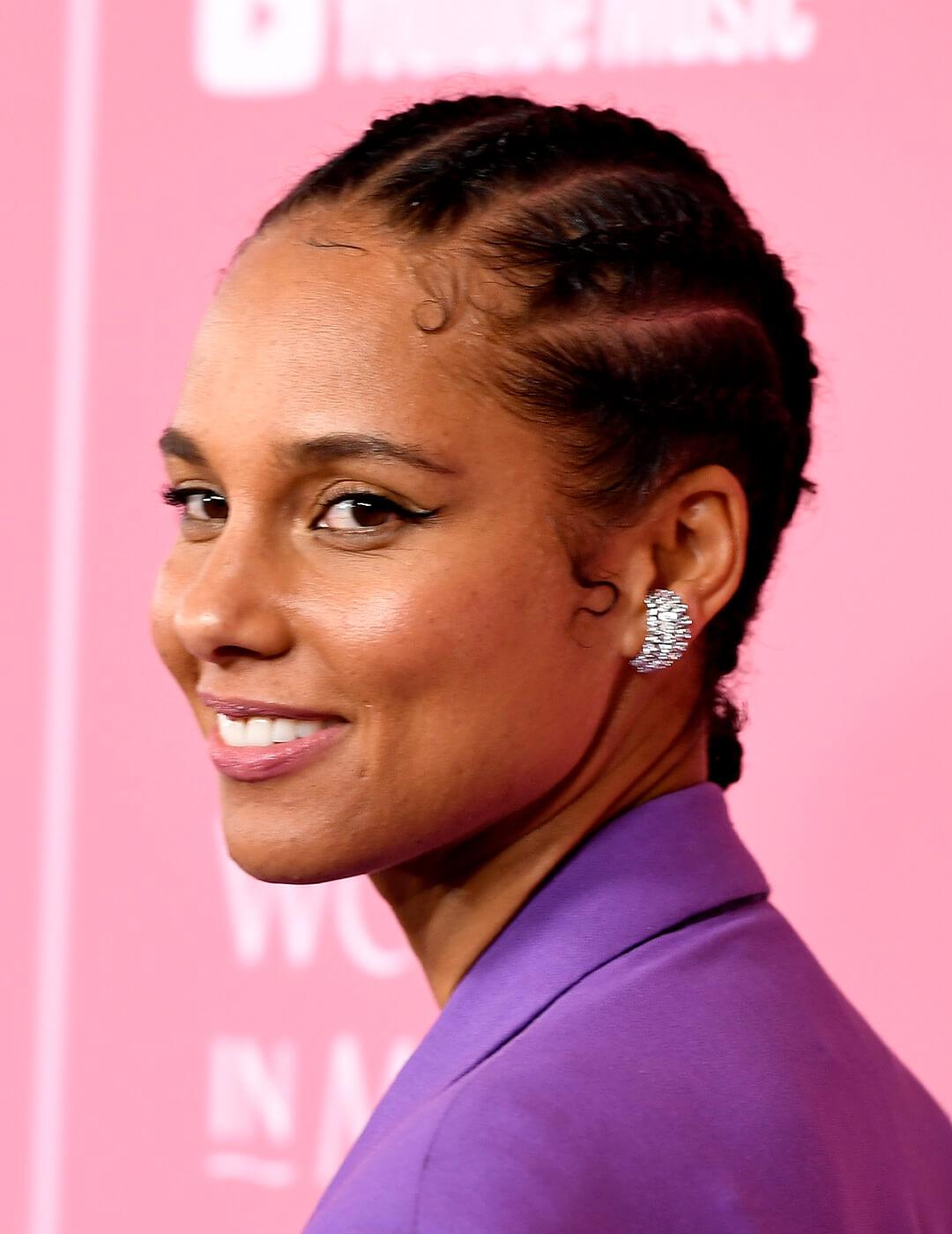 Alicia Keys looking chic in a purple suit, diamond-studded earrings, and cornrow braided hairstyle Mobile