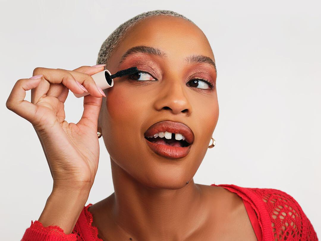 Close-up of a young woman applying mascara. Desktop
