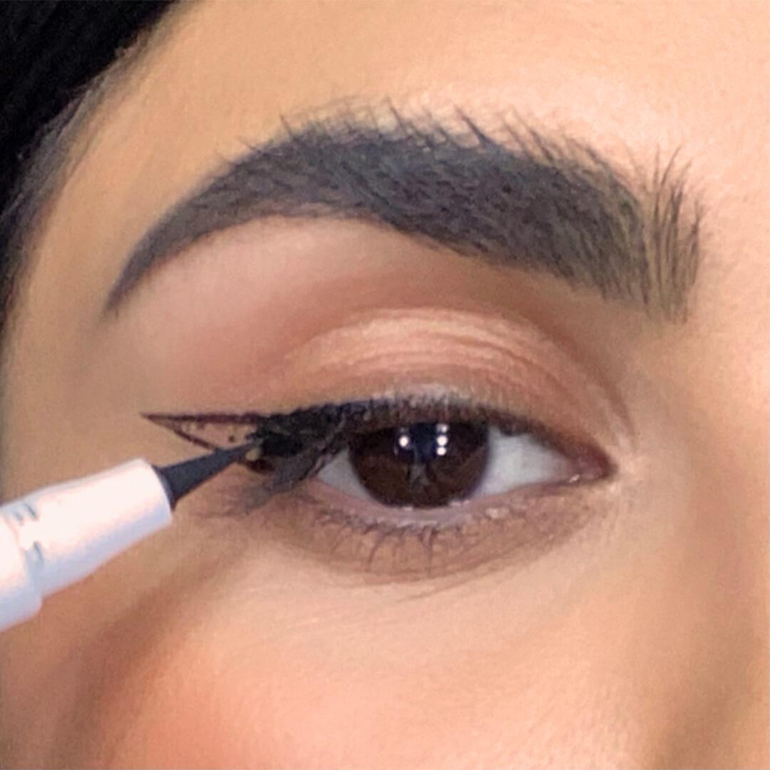 Close-up of a woman filling in her cat eye guide with an eyeliner Desktop