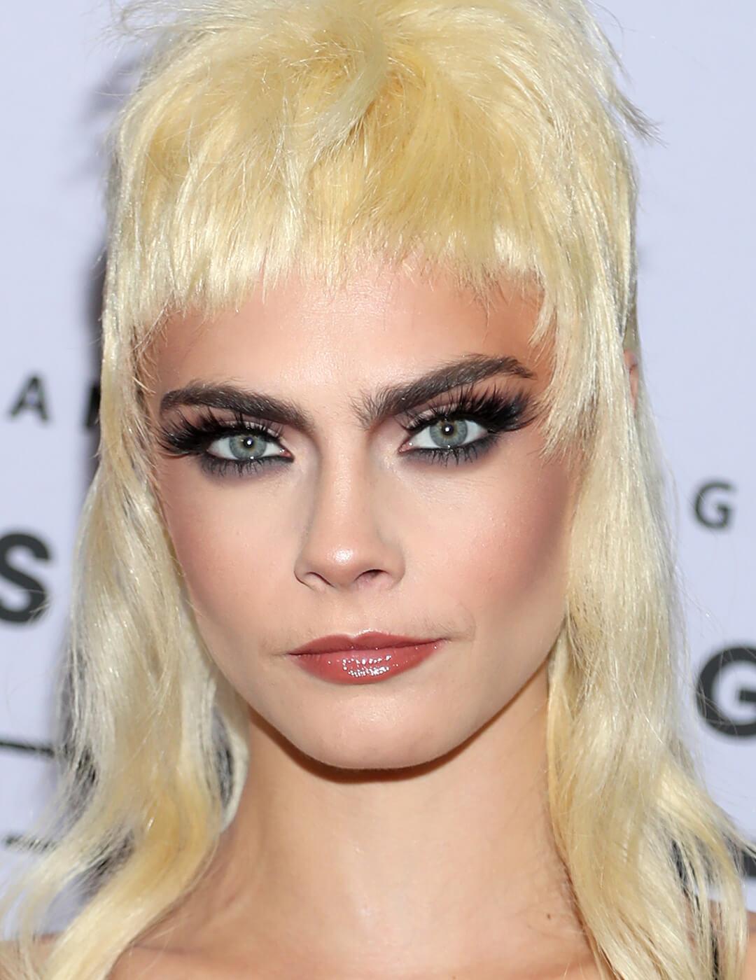 Cara Delevingne rocking a blonde mullet hairstyle and smoky eyeshadow makeup look Mobile