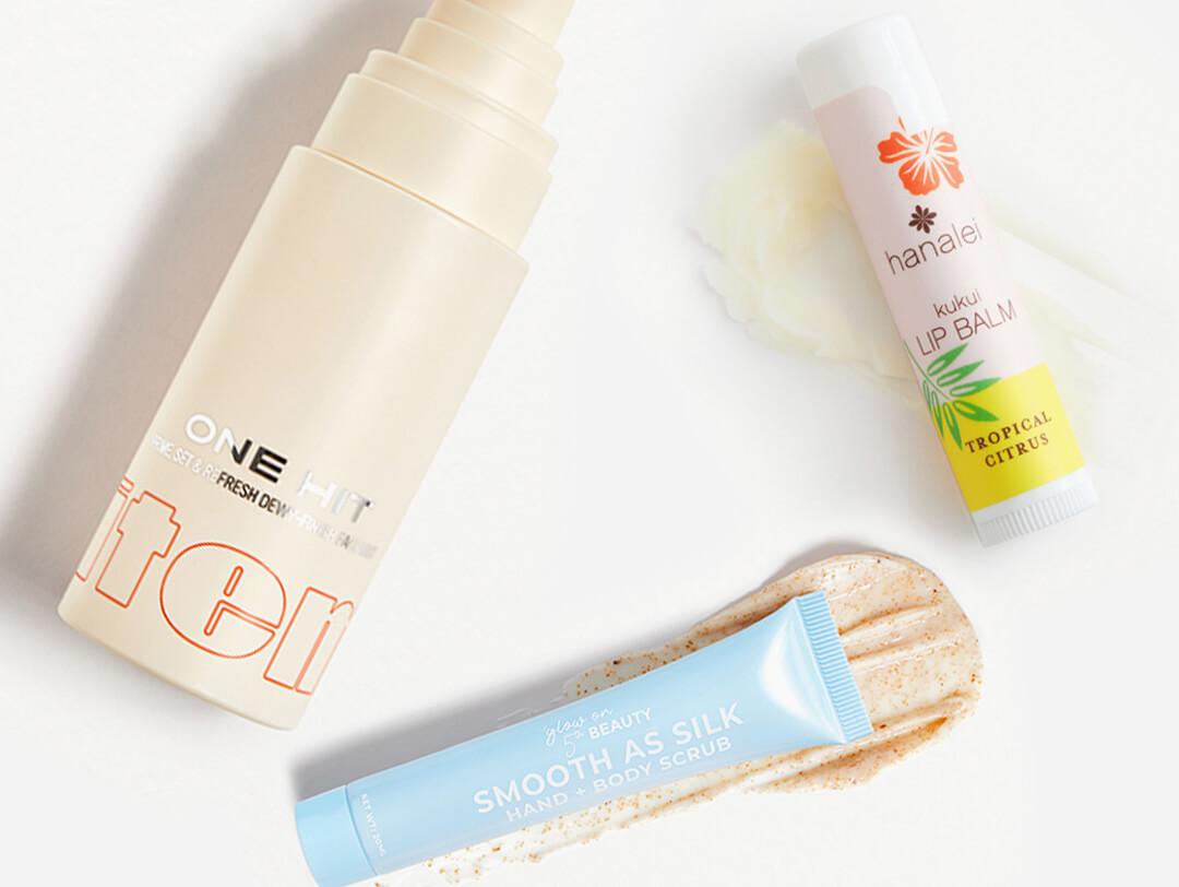 Image of ITEM BEAUTY One Hit Triple Action Setting Mist, HANALEI COMPANY Kukui Lip Balm in Tropical Citrus, and GLOW ON 5TH Smooth As Silk Hand + Body Scrub swatched on white background Desktop