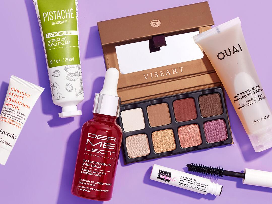 Skincare, makeup, and hair care products from October 2021 Glam Bag Plus scattered on purple background Desktop