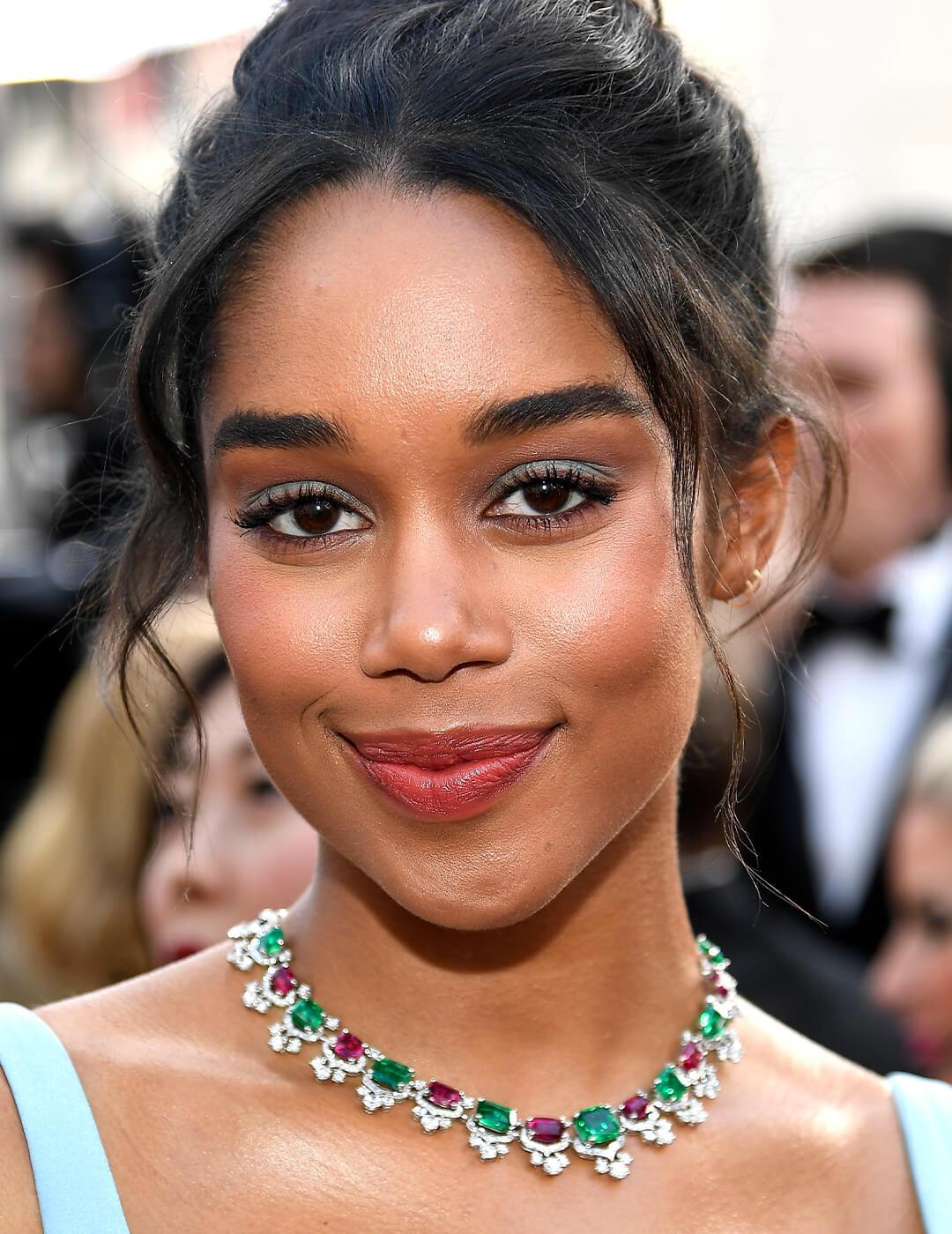 Laura Harrier rocking a baby blue eye makeup look, ruby and emerald necklace and baby blue dress Desktop