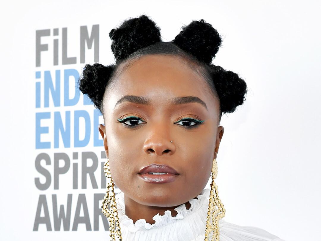KiKi Layne rocking Bantu knots hairstyle and gold, dangling earrings Desktop