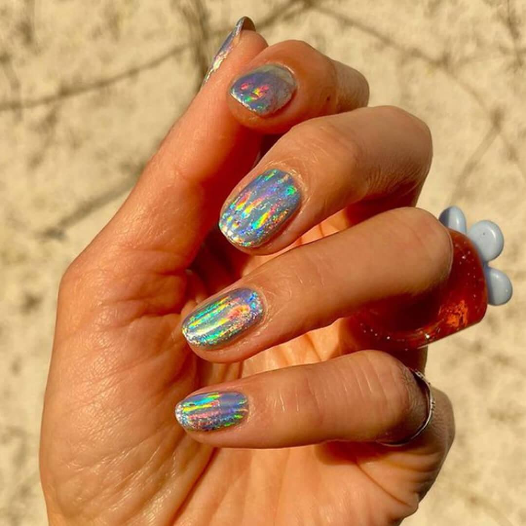 Close-up of a woman's hand with rainbow foil nail art Mobile
