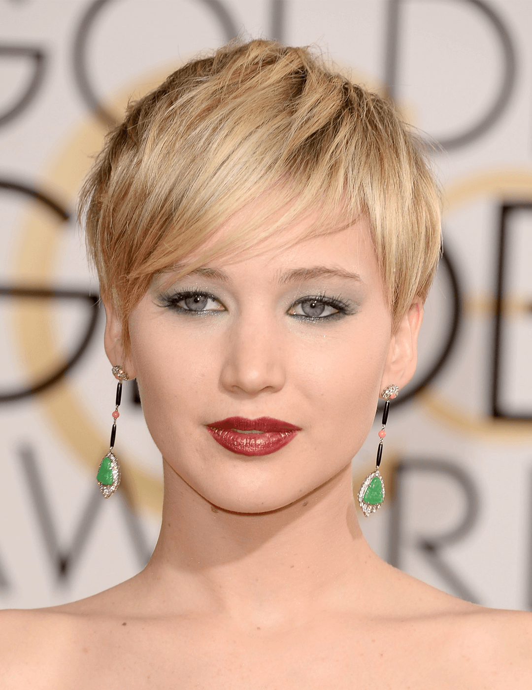 Jennifer Lawrence rocking a sultry makeup look, dangling emerald earrings, and messy pixie hairstyle Mobile