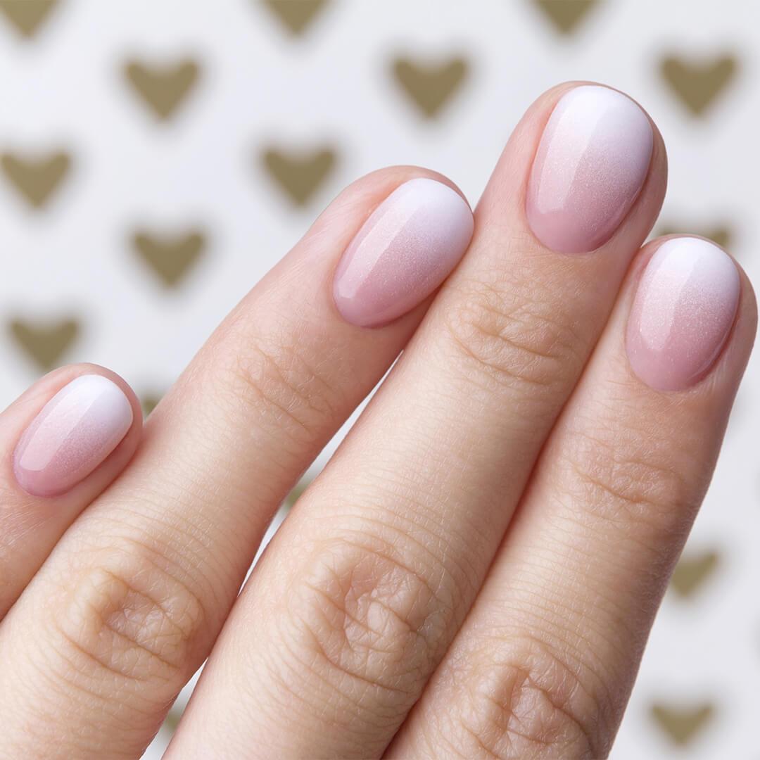 A closeup of pink ombre nails that go from pink to white Desktop