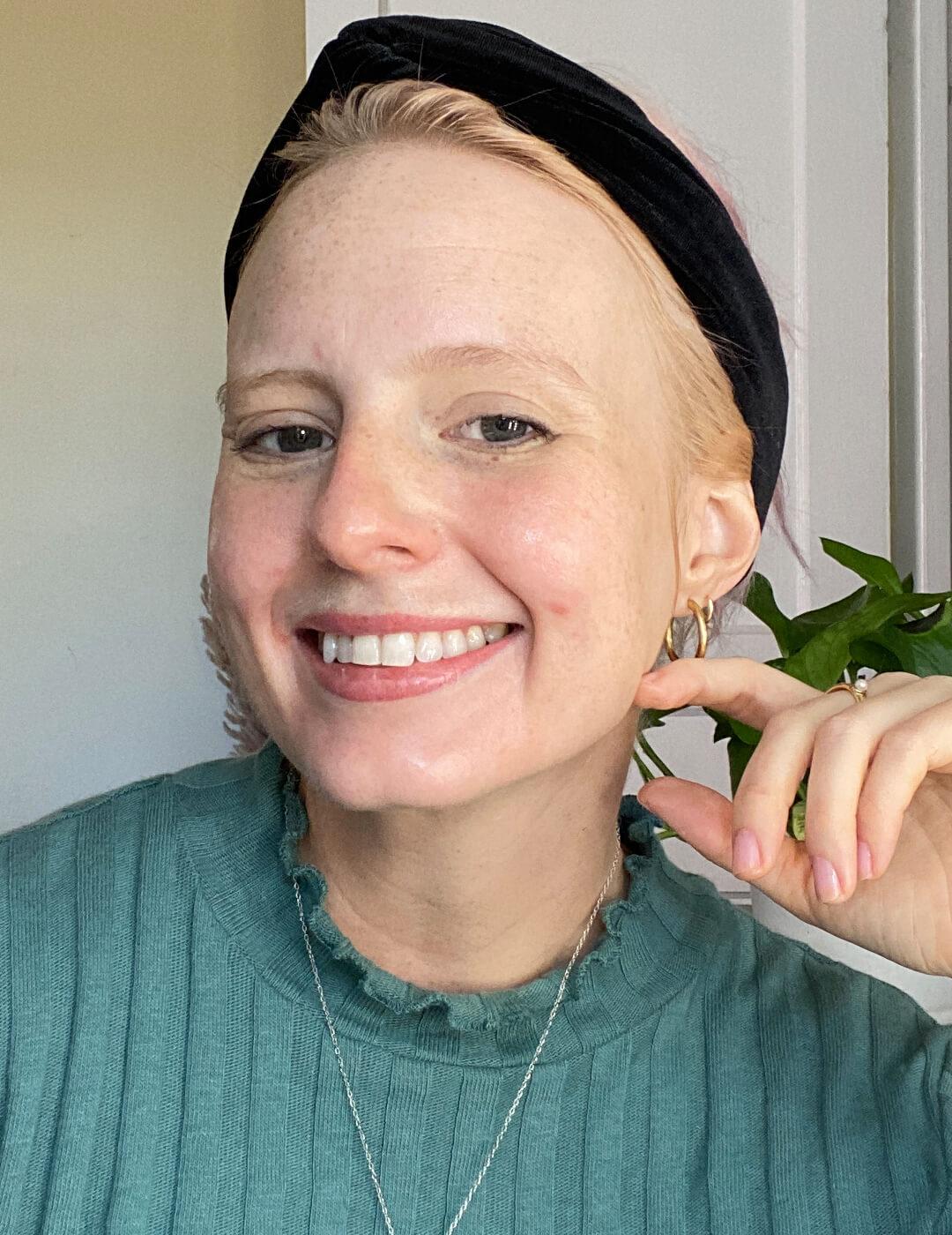Hannah Cassidy wearing green sweater and black headband smiling and posing Desktop