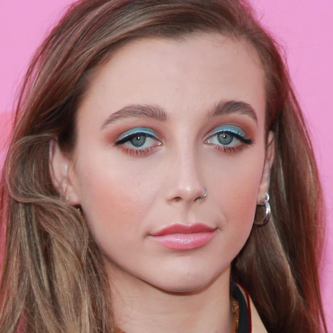 Close-up image of Emma Chamberlain rocking a red and blue-green eyeshadow look paired with a pink lipstick Desktop