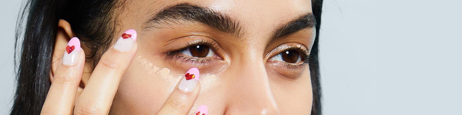 Close-up image of a model putting concealer under her eye Desktop