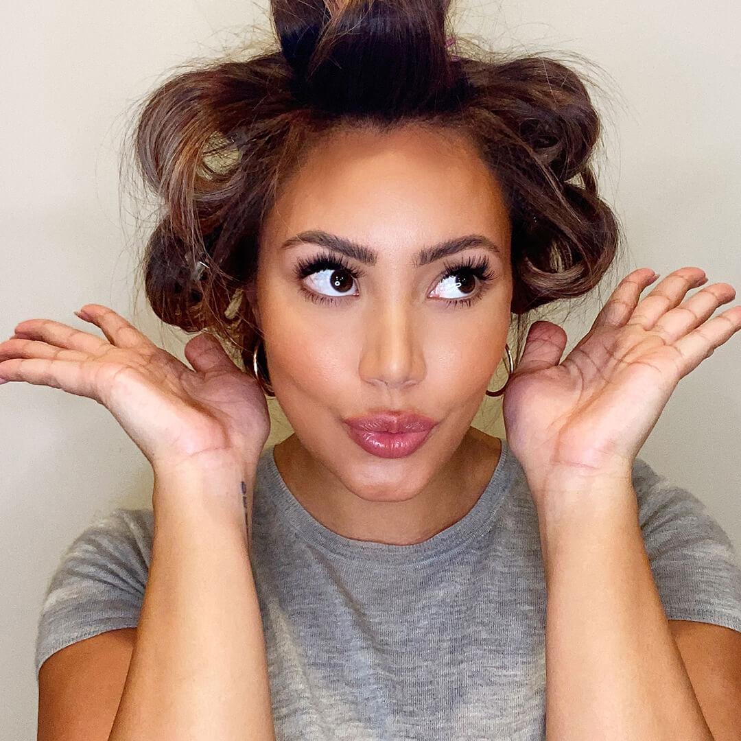 Close-up image of Cynthia Alvarez with pinned hair sections funnily posing Mobile