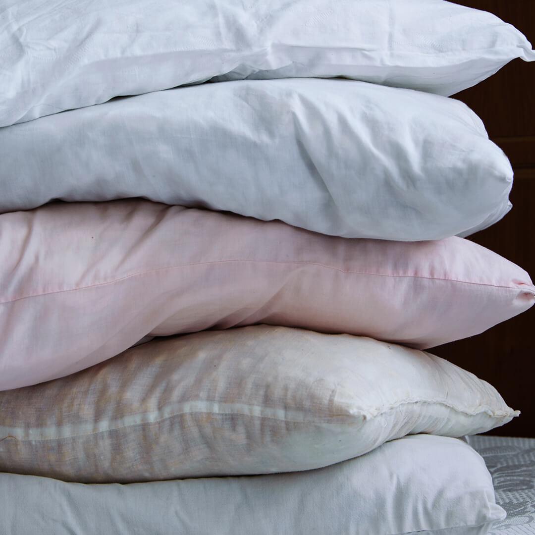 A closeup photo of stacked pillows on a bed Desktop