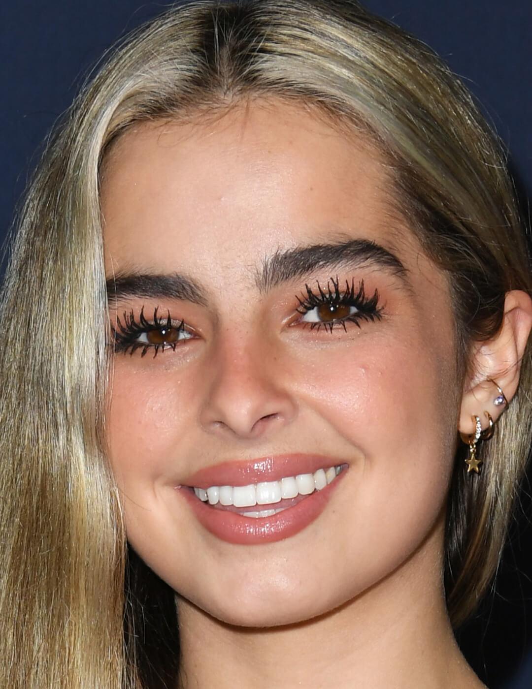 Close-up of a smiling Addison Rae with neutral makeup and fluttery eyelashes Mobile