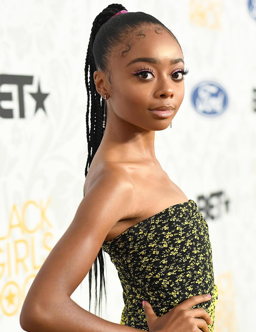 Skai Jackson looking glamorous in a yellow and black tube dress and braided ponytail hairstyle Mobile