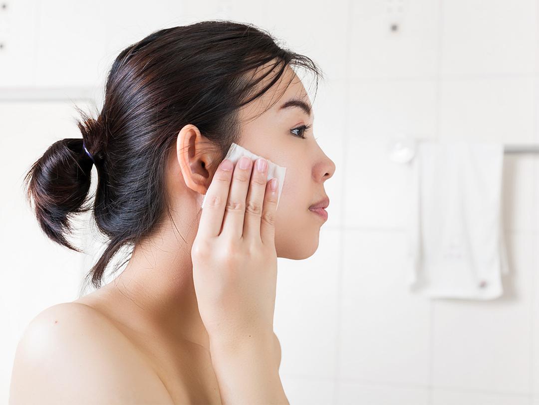 An image of a woman cleaning her face in the bathroom Desktop
