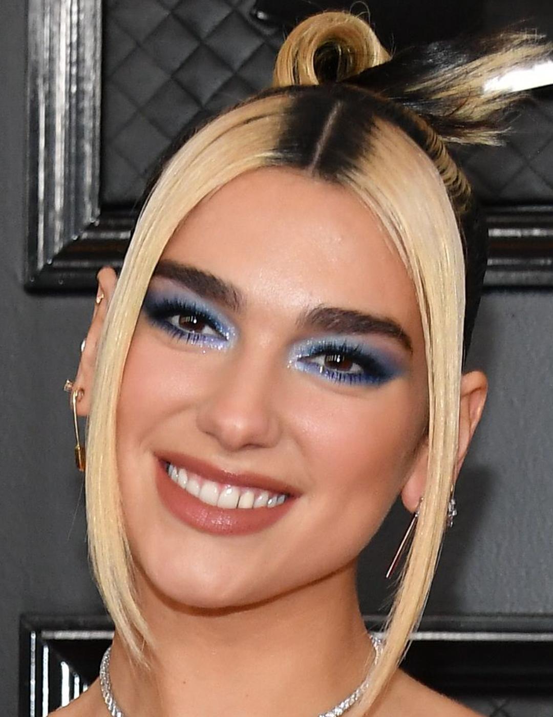 A photo of Dua Lipa looking fab with blonde hair and rooted streaks Mobile