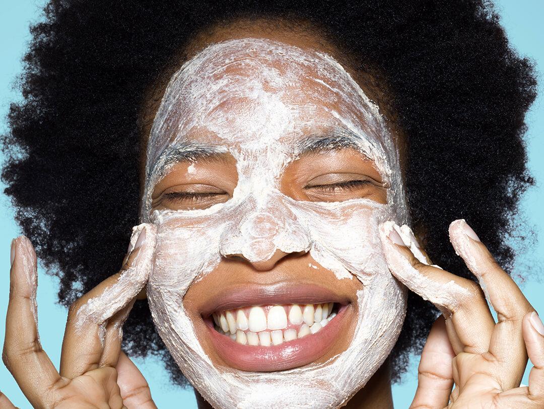 Young female applying face mask Desktop