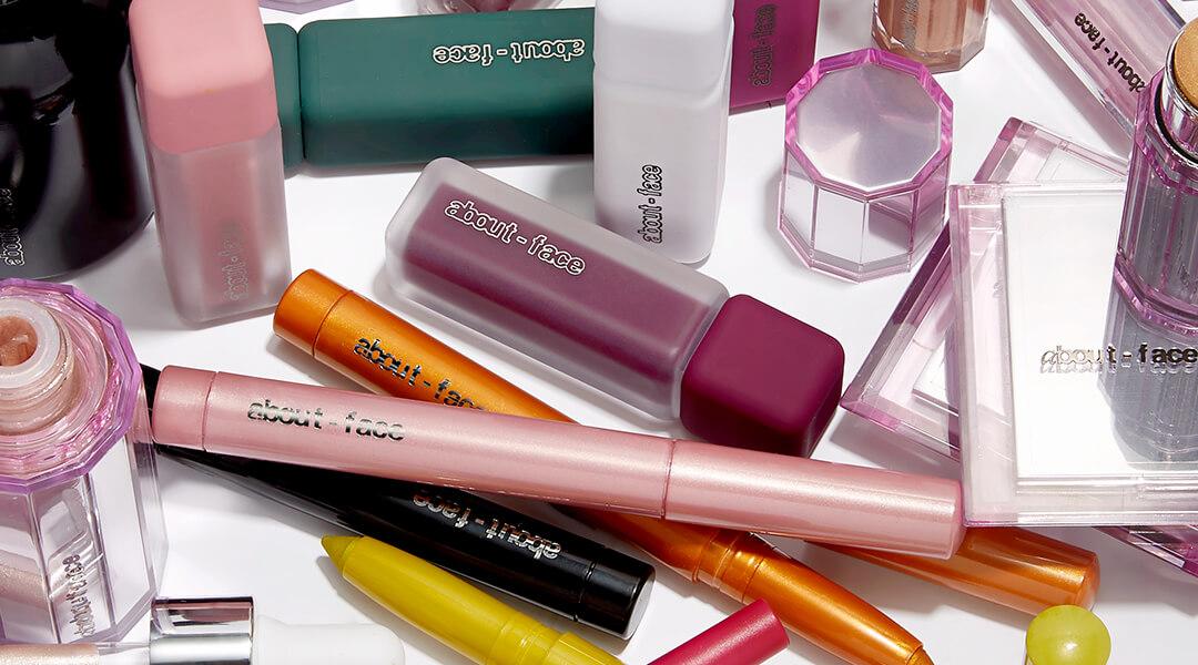 Different makeup products from ABOUT-FACE makeup brand on white background Desktop