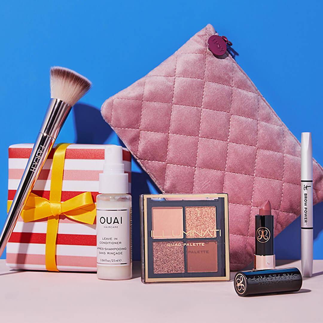 Pink quilted makeup pouch, makeup, skincare, and hair care products and tools on blue background Mobile