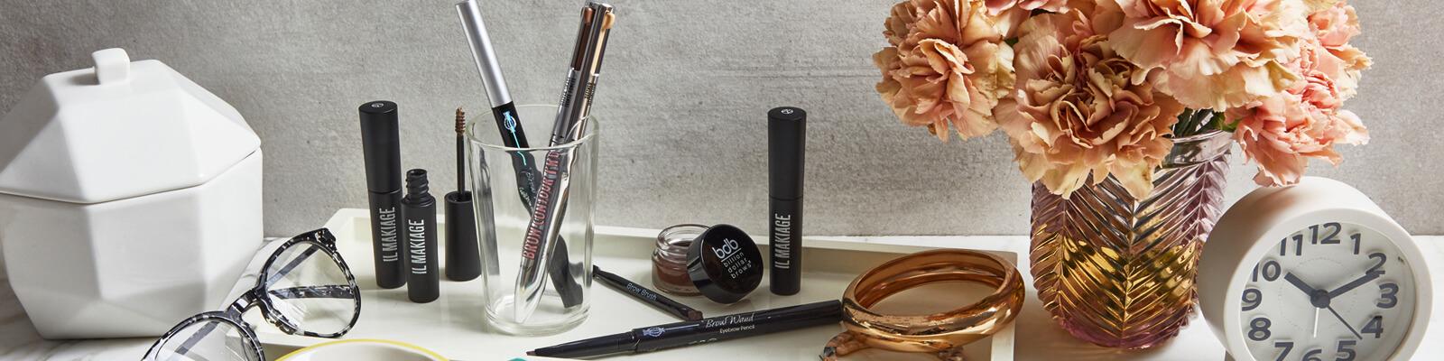 A flatlay image of eyebrow products from different brands Desktop