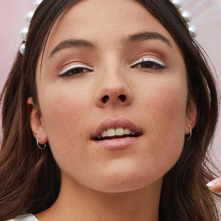 Images of a model with a bold, white eyeliner look Mobile