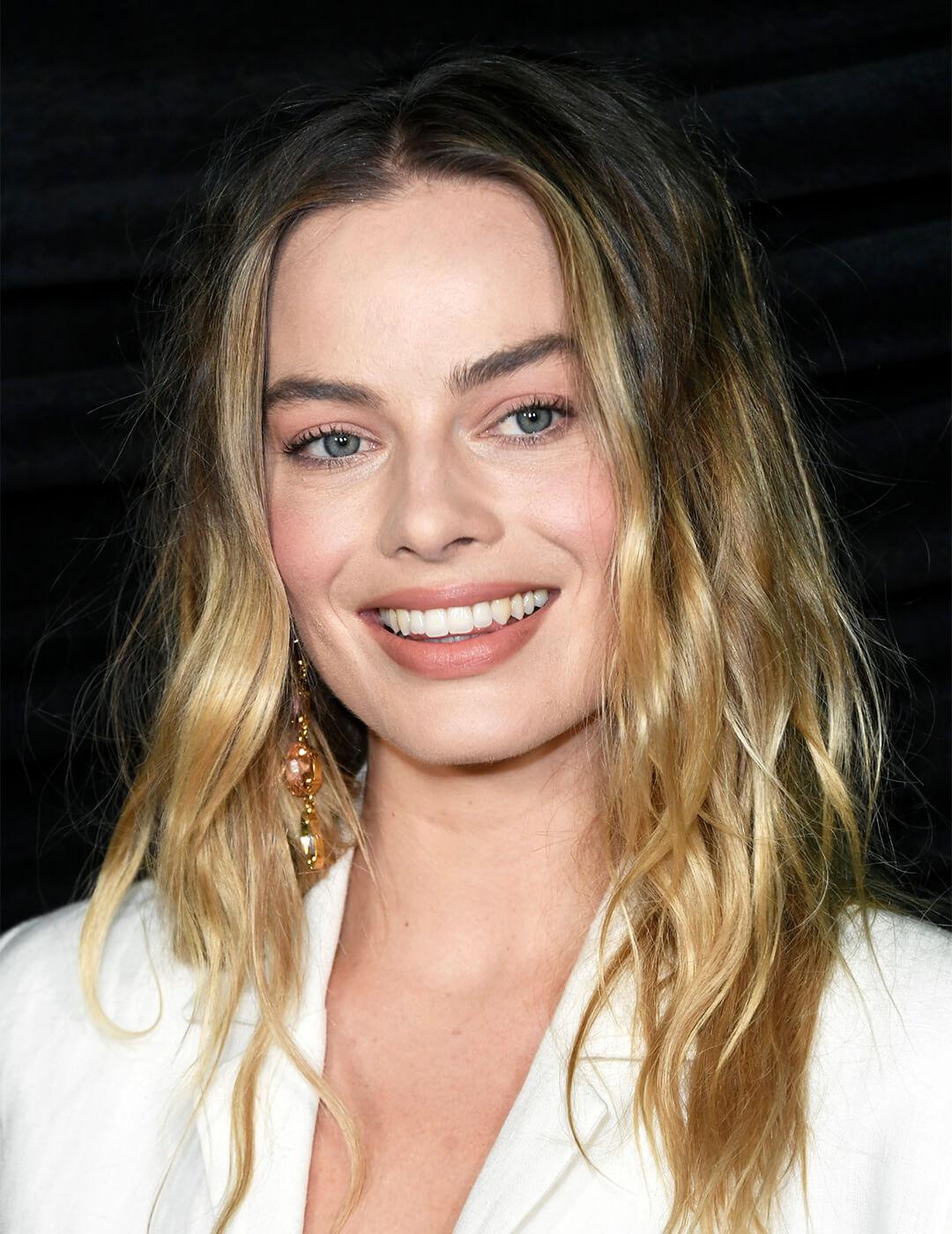 Margot Robbie wearing a white suit and loose waves hairstyle smiling Desktop