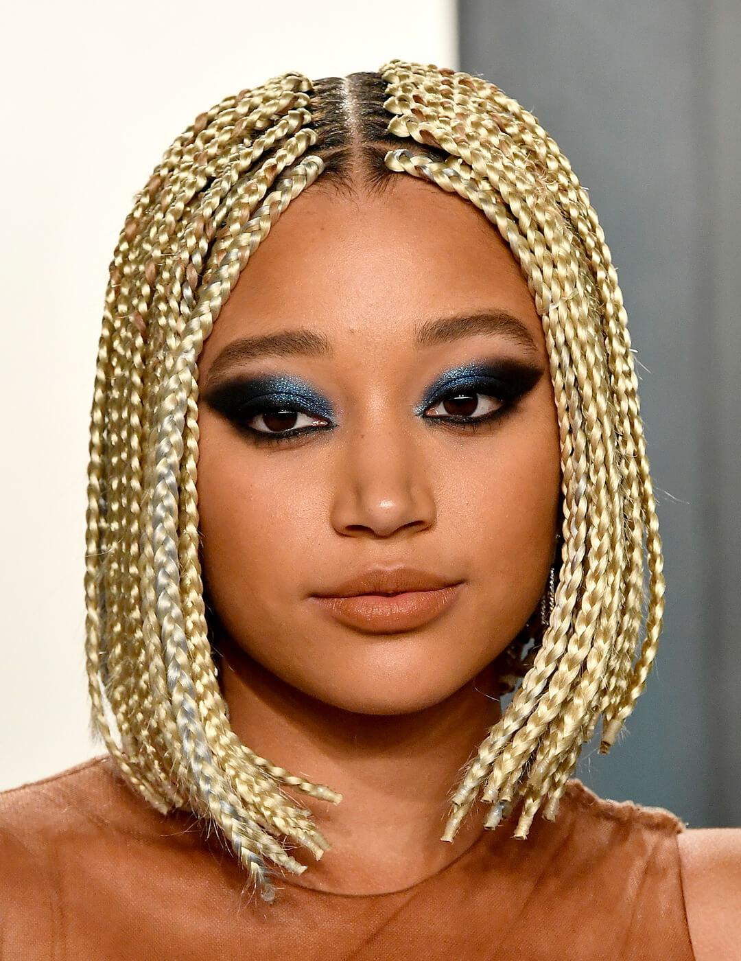 A photo of Amandla Stenberg with gold-colored braided hair and defined smokey eyeshadow Desktop